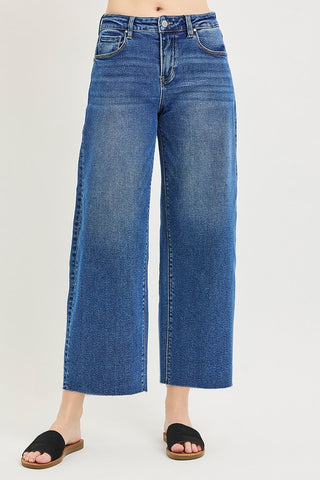 Medium wash blue slouchy crop barrel jeans with wide leg, raw hem, and black slide sandals.