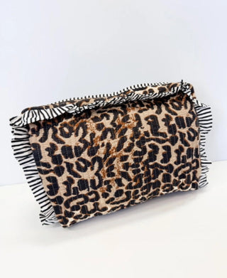 Quilted leopard print cosmetic bag with black and white striped ruffle trim detail.