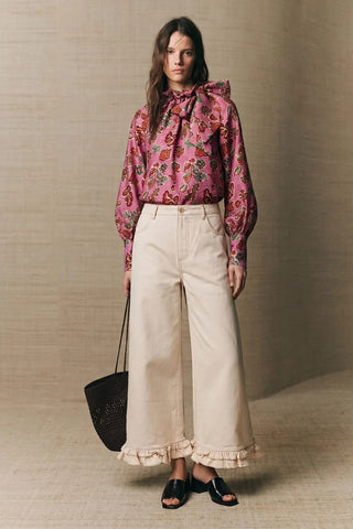 Pink floral print blouse with bow ruffle neckline and long billowy sleeves, worn tucked in.
