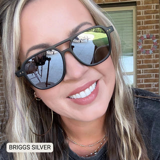 Woman wearing Briggs polarized aviator sunglasses with black frames and silver mirrored lenses outdoors.