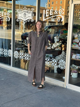 Taupe gray midi shirt dress with ruffle collar, puff sleeves, and button-front detail, worn with sandals.