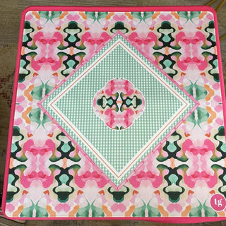 Mahjong mat featuring a symmetrical floral pattern in pink, green, and orange with a central diamond gingham design.