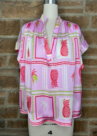 Pink tropical print short sleeve top with red pineapple and palm tree pattern, V-neckline with placket detail.