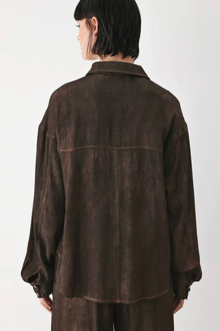 Dark brown oversized woven shirt jacket with contrast stitching details, worn as a matching set.