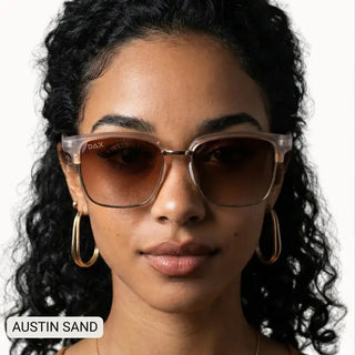 Woman wearing Austin Sand polarized square sunglasses with translucent beige frames and brown gradient lenses.