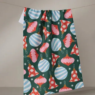 Ornamenta Tea Towel featuring retro Christmas ornaments, bells, and snowflakes on a dark green background.