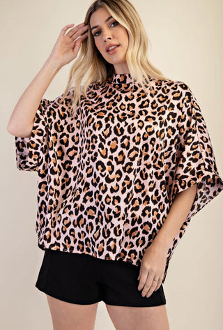 Pink leopard print mock neck oversized top with short sleeves, paired with black shorts.