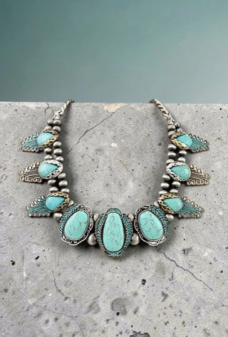 Western-style statement necklace featuring faux turquoise gemstones in silver Navajo pearl bead settings with decorative frin