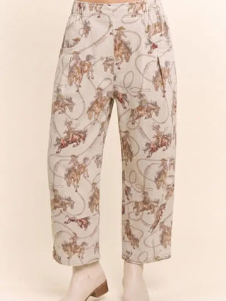 Cream relaxed-fit crop pants featuring an all-over Western rodeo cowboy and horse lasso print.