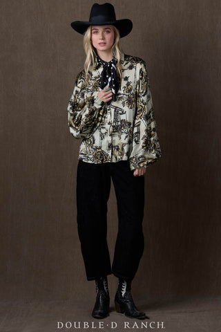 Cream and gold floral oil derrick print satin blouse with wide sleeves, styled with black hat and jeans.