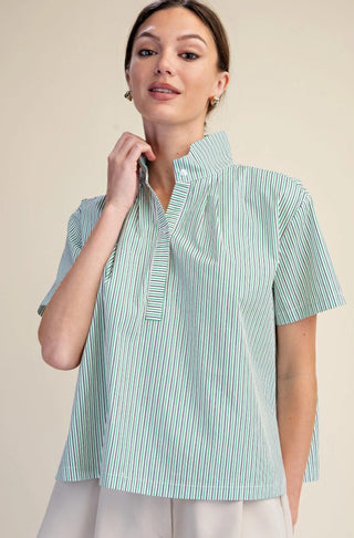 Woman wearing a green and white striped stand collar short sleeve pullover shirt with button placket.
