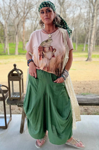 Flowy olive green wide-leg harem pants with elastic waist, worn with a frog graphic tee.