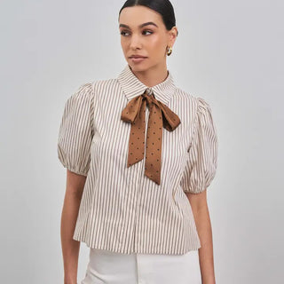 White and black striped puff-sleeve blouse with brown polka dot satin bow tie at collar.