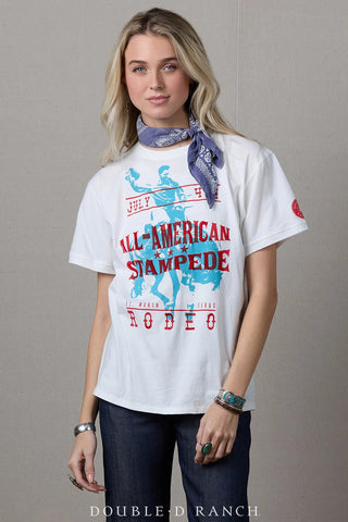 White graphic tee featuring red and blue All-American Stampede Rodeo print, styled with a blue bandana scarf.
