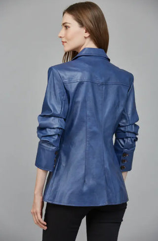 Woman wearing a navy blue faux leather blazer with scrunched sleeves, flap pockets, and button details.