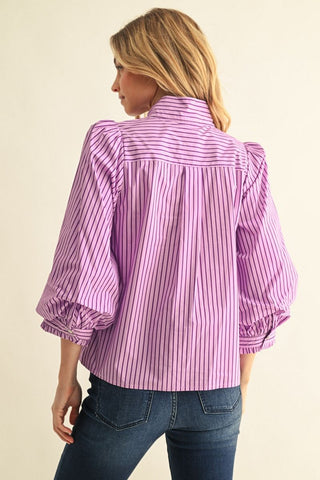 Purple and black striped button-down top with 3/4 puff sleeves, ruffled cuffs, and tie neck detail.