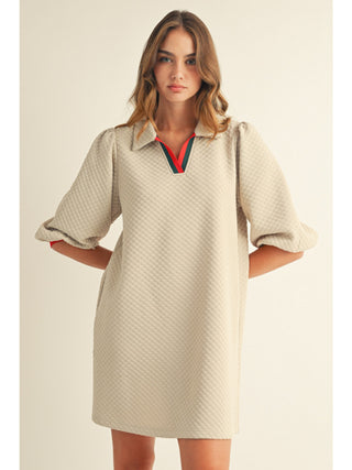 Beige textured quilted mini dress with puff sleeves, polo collar, and red-green stripe trim detail.