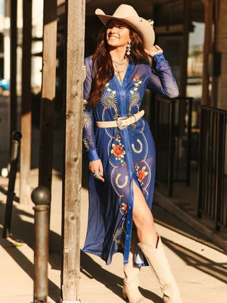 Denim blue floral mesh maxi duster with horseshoe embroidery, worn belted with cowboy hat and boots.