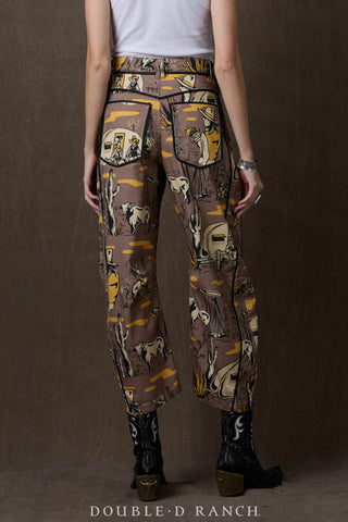 Brown western-print barrel pants featuring cowboy, cattle, and desert scenes in gold and cream tones.