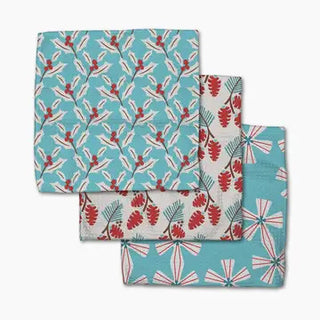 Set of three teal and white dishcloths featuring red holly berries and pine cone prints.