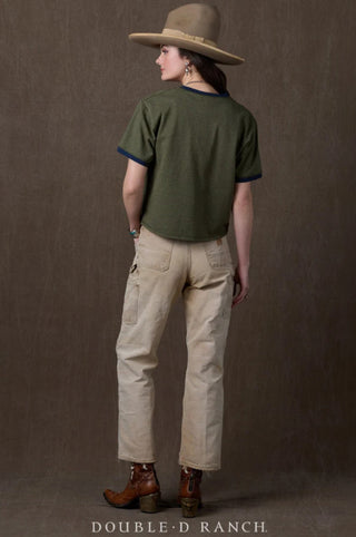 Woman wearing olive green ringer tee with navy blue trim, paired with khaki cargo pants and brown western boots.