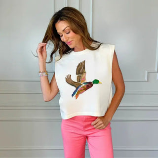 White sleeveless tank top featuring a colorful flying mallard duck graphic, paired with pink jeans.