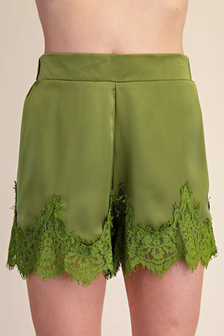 Olive green satin shorts featuring intricate floral lace trim detail along the scalloped hemline.