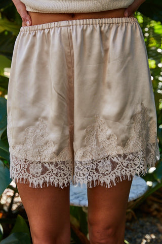Maisy Satin Lace Shorts in champagne beige with intricate cream lace trim and elastic waistband.