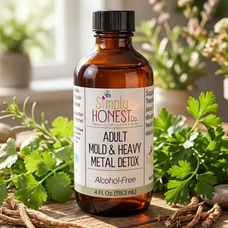 Amber glass bottle of Simply Honest Co. Adult Mold & Heavy Metal Detox supplement, alcohol-free, 4 fl oz, surrounded by fresh
