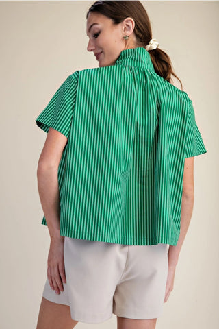 Green and white striped short sleeve shirt with stand collar, boxy fit, worn with white shorts.