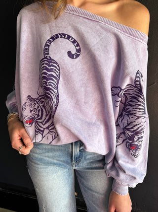 Lavender acid-wash off-shoulder sweatshirt featuring purple tiger graphics on front and sleeves with red accents.
