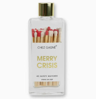 Clear glass bottle with gold lid containing red and white safety matches, labeled "Merry Crisis" by Chez Gagné.