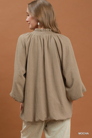 Mocha balloon sleeve split neck blouse with smocked neckline, gathered back, and flowy silhouette.