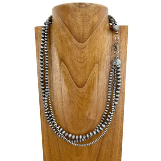 Three-strand silver Navajo pearl bead necklace displayed on wooden bust, oxidized finish, lobster clasp closure.