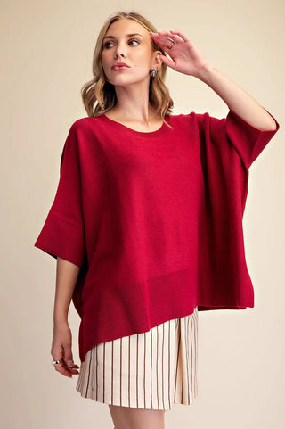 Red oversized round neck short sleeve pullover sweater with ribbed hem details, worn casually.