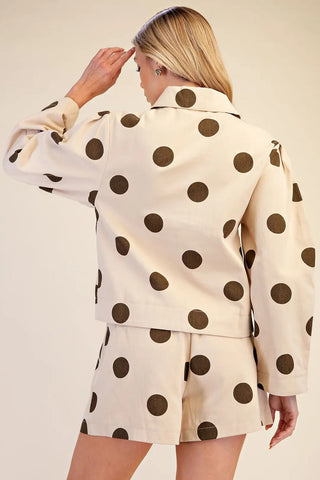 Cream blazer jacket with large brown polka dots, notched collar, long sleeves, paired with matching shorts.