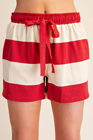 Red and white wide-stripe sweat shorts with elastic waistband and red drawstring tie.