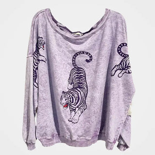 Oversized lavender acid-wash sweatshirt featuring black and white tiger graphics on chest and sleeves.