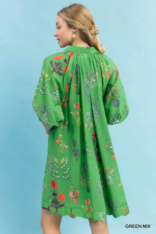 Bright green mini dress with multicolor botanical floral print, puffed sleeves, collared neckline, and A-line silhouette.