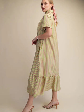 Light yellow striped midi dress with stand collar, short sleeves, ruffled hem, worn with beige heels and pink hair ribbon.