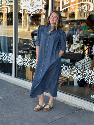 Denim blue midi shirt dress with ruffle collar, puff sleeves, and button-front styling, paired with leopard print flats.