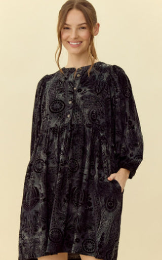 Velvet jacquard dress with round neckline and button placket, three quarter puffed sleeves, and side pockets.