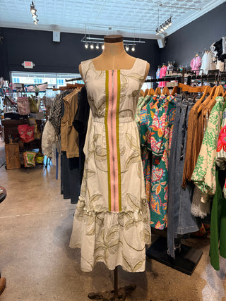 White sleeveless midi dress with olive leaf print, front zipper detail, and pink stripe accent.