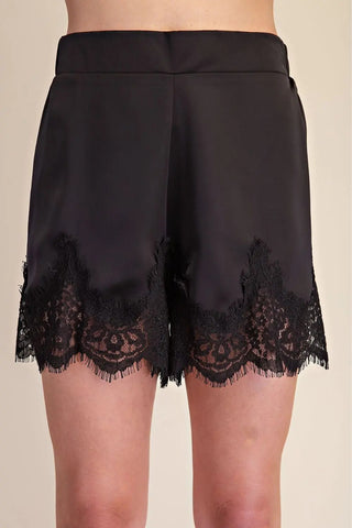 Black satin shorts with scalloped eyelash lace trim detail along the hemline, front view.