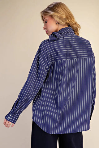 Navy blue and white pinstripe oversized button-down shirt with long sleeves, back yoke detail, and buttoned cuffs.