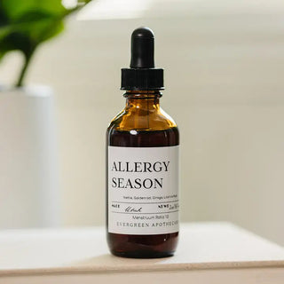 Amber glass dropper bottle labeled "Allergy Season" herbal tincture by Evergreen Apothecary, made in Utah.