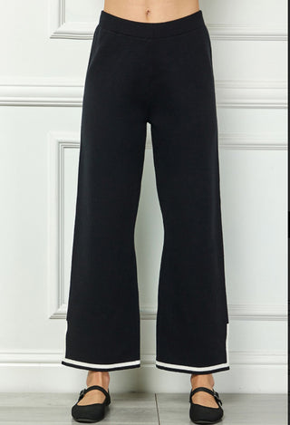 Black wide-leg knit sweater pants with white contrast stripe trim at hem, elastic waistband.