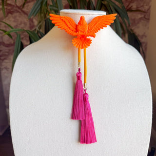 Orange eagle brooch bolo tie with golden yellow cord and two fuchsia pink silk tassels on display bust.