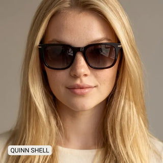Woman wearing Quinn Shell black square-frame sunglasses with gold hardware and gradient brown lenses.