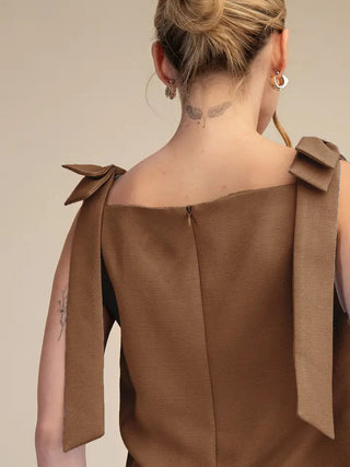 Brown textured sleeveless mini dress with decorative shoulder bow ties, back zipper closure, square neckline.